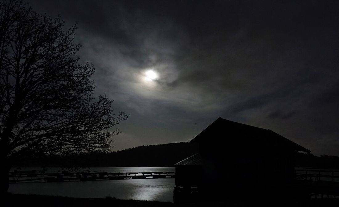 A full moon over the water at night